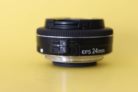 Foto de Lente de cámara DSLR - lente de cámara digital de 24 mm con fondo borroso amarillo - Imagen libre de derechos