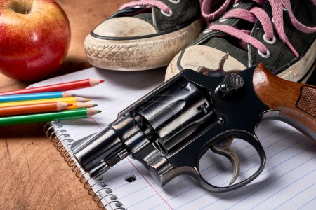 Téléchargez les photos : Fournitures scolaires sur un bureau avec un pistolet - en image libre de droit