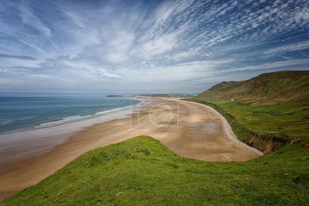 A landscape scene of the beach at Rhossili Bay on the Gower Peninsula in Wales UK