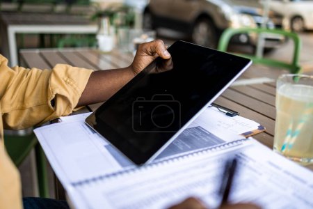 Foto de Primer plano del hombre afroamericano sosteniendo tableta digital al aire libre. - Imagen libre de derechos