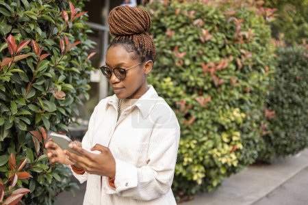 Téléchargez les photos : Portrait de femme afro-américaine utilisant un téléphone portable . - en image libre de droit