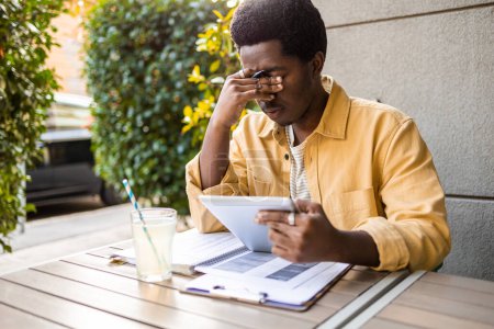 Photo for Young African American man studying online course looking stressed. - Royalty Free Image
