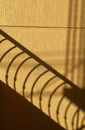 Foto de Pared amarilla con sombra de barandilla en la pared. - Imagen libre de derechos