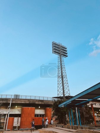 Photo for Itagui, Antioquia, Colombia. February 12, 2024: Ditaires stadium big led light with blue sky and lightning in the sky. - Royalty Free Image