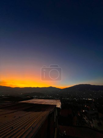 Colorido atardecer con cielo azul y naranja. Vista de la ciudad de Medellín.