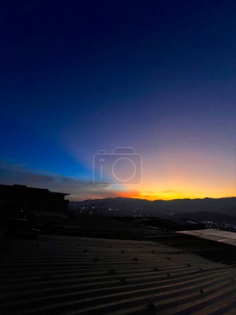 Bunter Sonnenuntergang mit blauem und orangefarbenem Himmel. Blick auf die Stadt Medellin.
