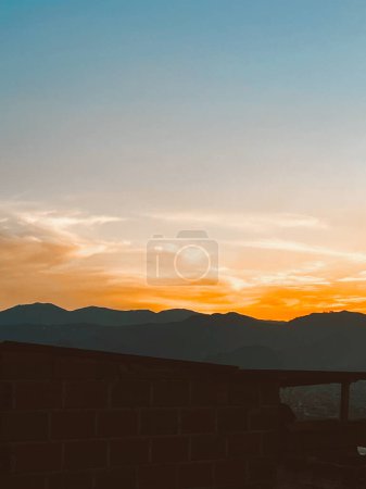 Hermosa puesta de sol con cielo anaranjado y enorme nube vista desde el barrio de Manrique. Medellín, Antioquia, Colombia.