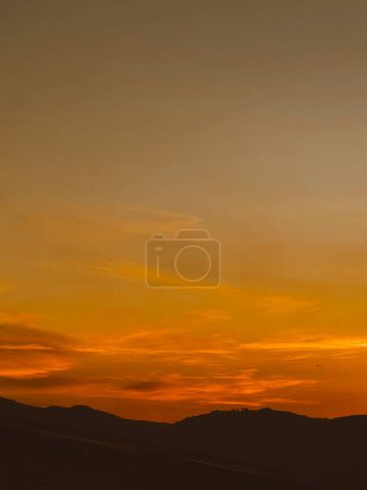 Hermosa puesta de sol con cielo anaranjado y enorme nube vista desde el barrio de Manrique. Medellín, Antioquia, Colombia.