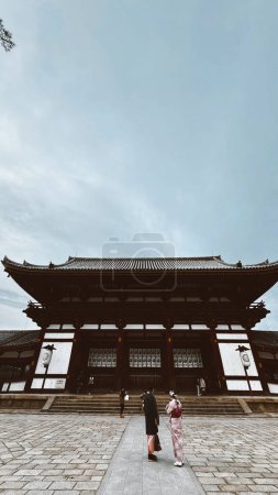 Foto de Nara, Japon. March 25, 2024: Daibutsu Buddhist temple and its facade with cloudy sky. - Imagen libre de derechos