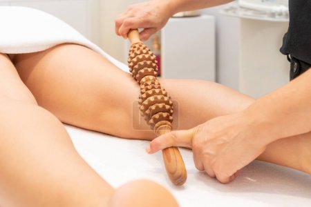 Téléchargez les photos : Madero Therapy Massage with Wooden Rolling Pin to stimulate the blood circulation. High quality photo - en image libre de droit