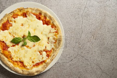 Leckere Margherita-Pizza mit frischen Basilikumblättern auf einem rustikalen Steintisch. Kulinarische Perfektion eingefangen in einer köstlichen Komposition. Hochwertiges Foto