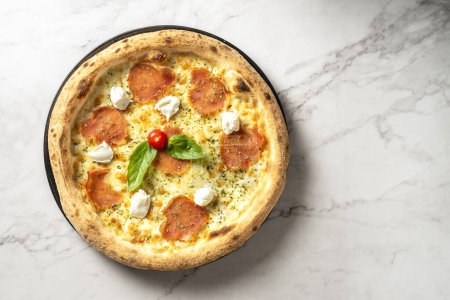 Italienische Pfefferoni und Büffelkäse-Pizza auf einem weißen Marmortisch. Kulinarische Perfektion für ein verführerisches Festmahl. Hochwertiges Foto