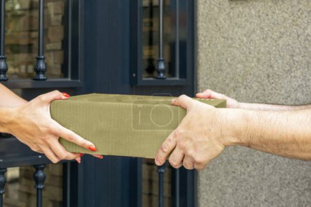 Express delivery service - hands of a courier delivering a package to a woman. High quality photo