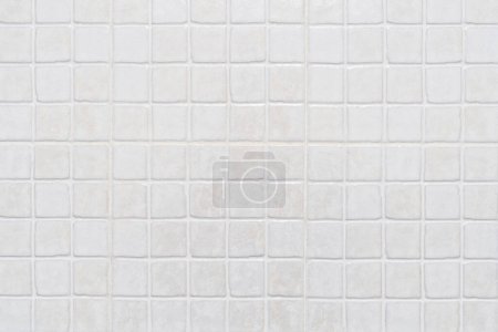 Close-up of a perfect grid of small white ceramic tiles with gold glitter forming a background. High quality photo