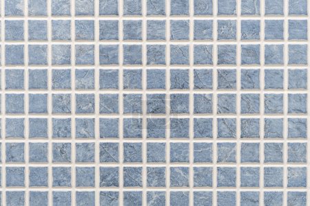 Close-up of a perfect grid of small blue ceramic tiles forming a background. High quality photo