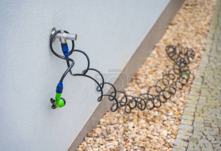 Garden spiral hose on the wall. High quality photo