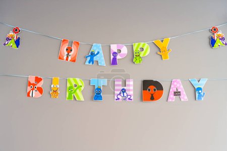 Happy Birthday paper sign with colorful monsters from virtual games. High quality photo
