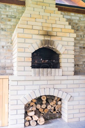 A white brick stove with soot from use, with a wood storage under the stove. Cottage core. High quality photo