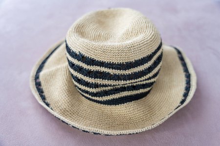 Comfortable beige beach raffia summer hat with black stripes. Fashion concept. High quality photo