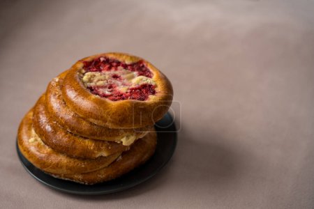 Czech round pies kolaches with strawberries and cottage cheese on a beige background. High quality photo