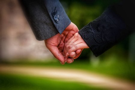 Téléchargez les photos : Un couple tenant la main dans un parc - en image libre de droit
