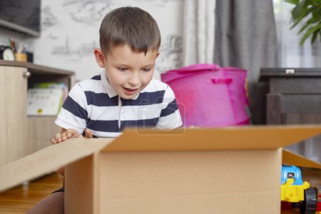 Photo for Young Boy Excited by Surprise in Cardboard Box. - Royalty Free Image