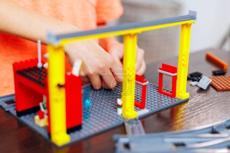 Close-up of a childs hands assembling a toy construction set with colorful pieces, focusing on creative play and development.