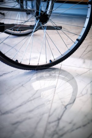 Rollstuhlrad spiegelt sich auf dem Boden in Villajoyosa