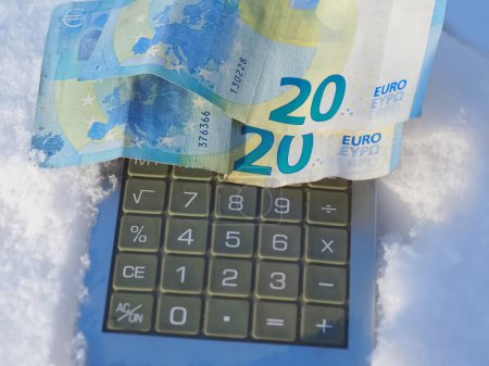 Téléchargez les photos : Calculatrice argent avec argent Euro dans la neige - en image libre de droit