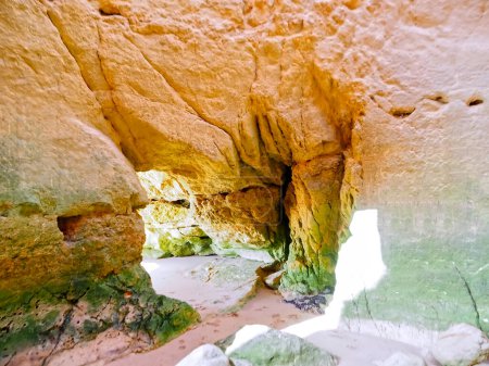 Foto de Mira dentro de una cueva con rocas verdes en Portimao Algarve Portugal - Imagen libre de derechos