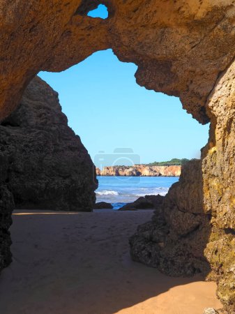 Un agujero en un acantilado abre una vista al océano en Algarve Portugal
