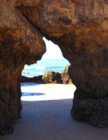 Foto de Un agujero en un acantilado abre una vista al océano en Algarve Portugal - Imagen libre de derechos