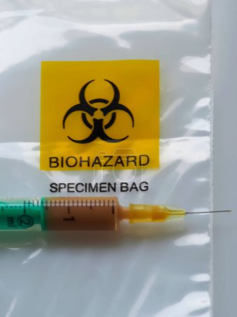 Téléchargez les photos : Sac à échantillons transparent Biohazard avec seringue et liquide brun - en image libre de droit