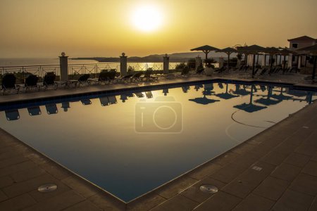 Foto de Atardecer dorado sobre la piscina del hotel. Mirando desde las colinas con vistas a Lassi, Cefalonia, Grecia. Foto de alta calidad - Imagen libre de derechos