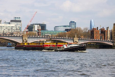 Foto de Remolcador tirando de una barcaza de contenedores por el río Támesis cerca de Westminster puente con horizonte de la ciudad. Foto de alta calidad - Imagen libre de derechos