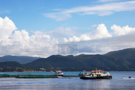 Fish farm on a Norwegian Fjord with mountains in the background. High quality photo
