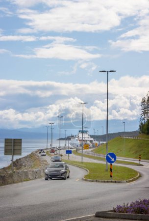 Autos fahren auf der Insel Aukra Norwegen von der Fähre weg. Hochwertiges Foto
