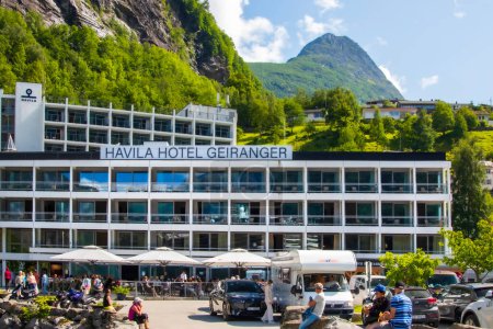 Téléchargez les photos : Geiranger, Norvège - 29 juillet 2023 : Hôtel Havila par une chaude journée d'été avec des touristes profitant de la journée. Photo de haute qualité - en image libre de droit