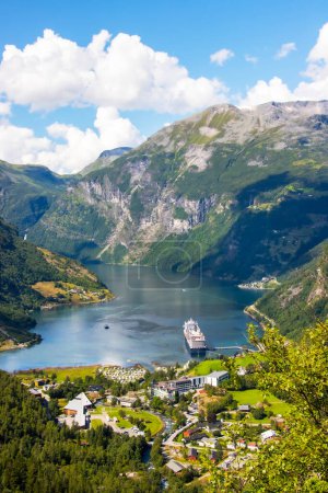 Portrait view across the town of Geiranger and the Fjord with a cruise ship . High quality photo