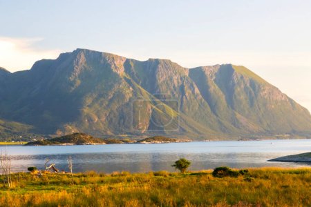 View across the Fjord from the island of Aukra Norway bathed in warm golden light . High quality photo