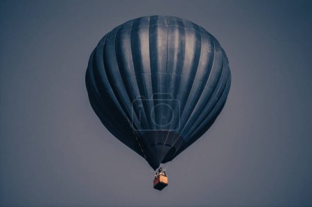 Téléchargez les photos : Grand ballon bleu foncé dans le ciel. Aérostat. Des gens dans le panier. Amusant. Animations estivales. Aventures romantiques. - en image libre de droit