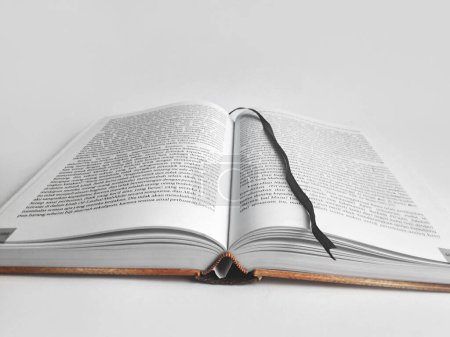 a thick book with its middle page open and a white background 2