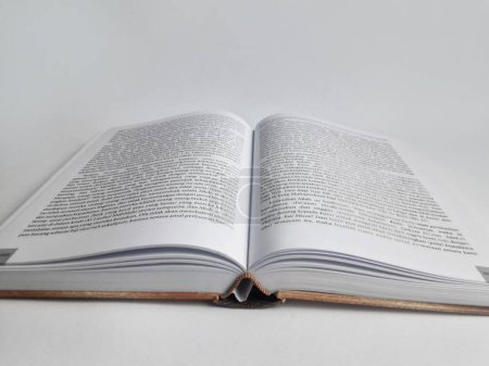 a thick book with its middle page open and a white background