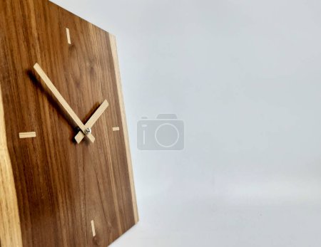 a wall clock made of teak wood and an isolated white background