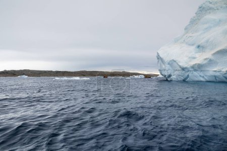 Zodiac boats full of tourists cruising around the iceberg