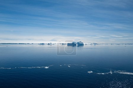 Foto de Atractivo paisaje antártico con tranquilas aguas azules del Mar de Weddell y grandes icebergs azules con la Isla Snow Hill al fondo, Península Antártica, Antártida - Imagen libre de derechos