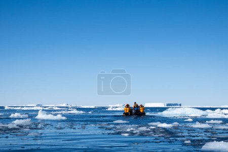 Photo for Snow Hill island, Antarctica - December 11, 2023 - Quark Expeditions zodiac boat approaches large icebergs through the melted ice in the Weddell Sea - Royalty Free Image