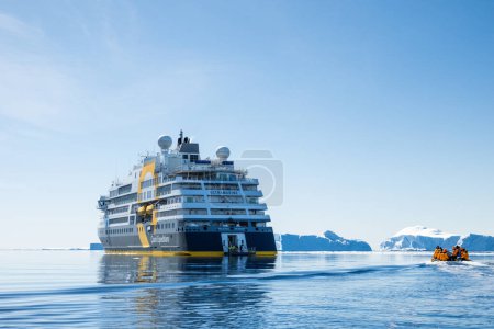 Téléchargez les photos : Snow Hill Island, Antarctique - 11 décembre 2023 - Zodiac boat with tourists approaches Quark Expeditions Bateau de croisière d'expédition outremer qui reste près des icebergs en Antarctique - en image libre de droit