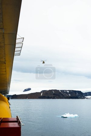 Foto de Isla Vega, Antártida - 12 de diciembre de 2023 - Expediciones Quark El helicóptero Airbus H145 regresa de un recorrido turístico por la Península Antártica. Disparo desde a bordo del crucero - Imagen libre de derechos