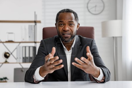 Téléchargez les photos : Homme d'affaires afro-américain tenant une consultation en ligne. Webcam portrait headshot. Webinaire en ligne, communication internet. Travail à distance - en image libre de droit